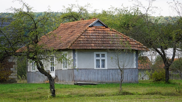 Bela kuća sa braon krovom na selu