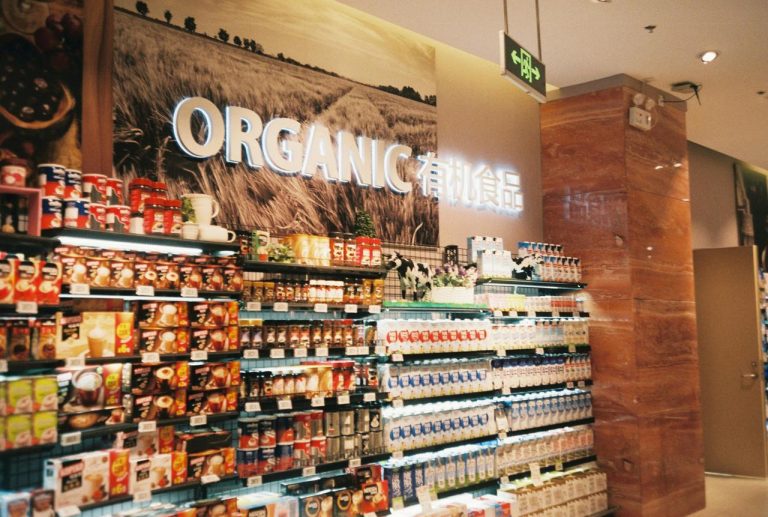 Police sa prehrambenim proizvodima ispod osvetljenog znaka ORGANIC